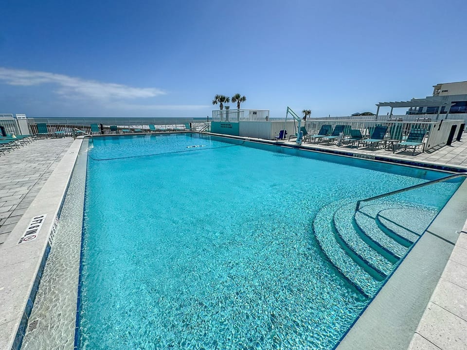 Dive into the pristine pool that blends seamlessly with ocean views, providing a perfect setting for relaxation and fun.