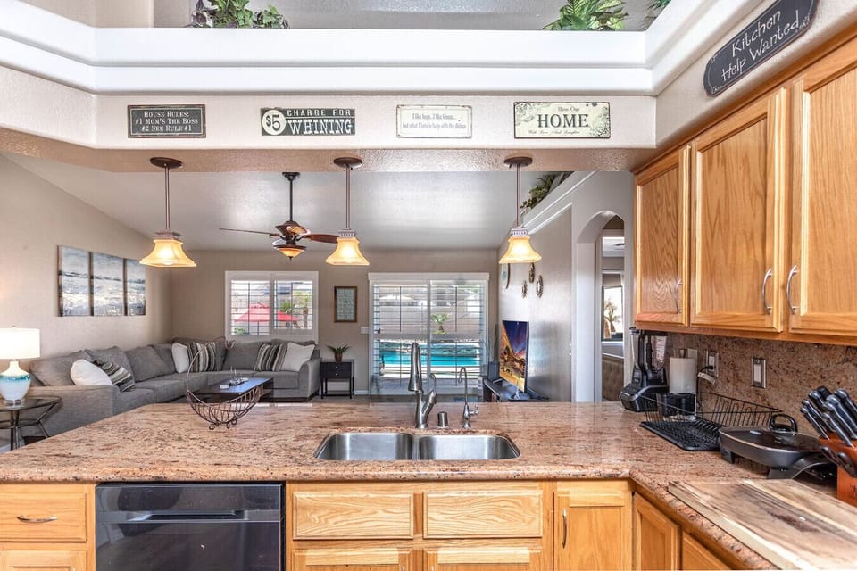 Open kitchen with granite counters, double sink, and view into the living area.
