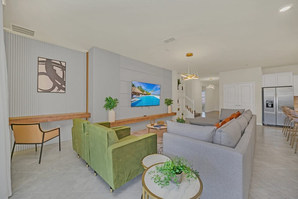 Cozy living room w/ green sofa, vibrant art & warm, welcoming energy.

