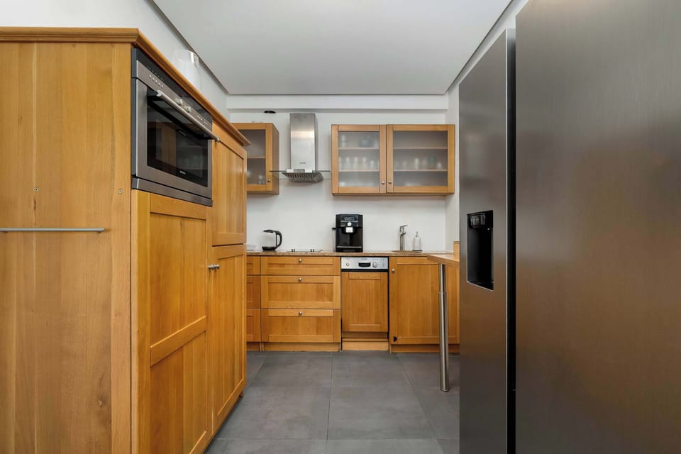 Kitchenette view with cabinets, countertop, and storage.