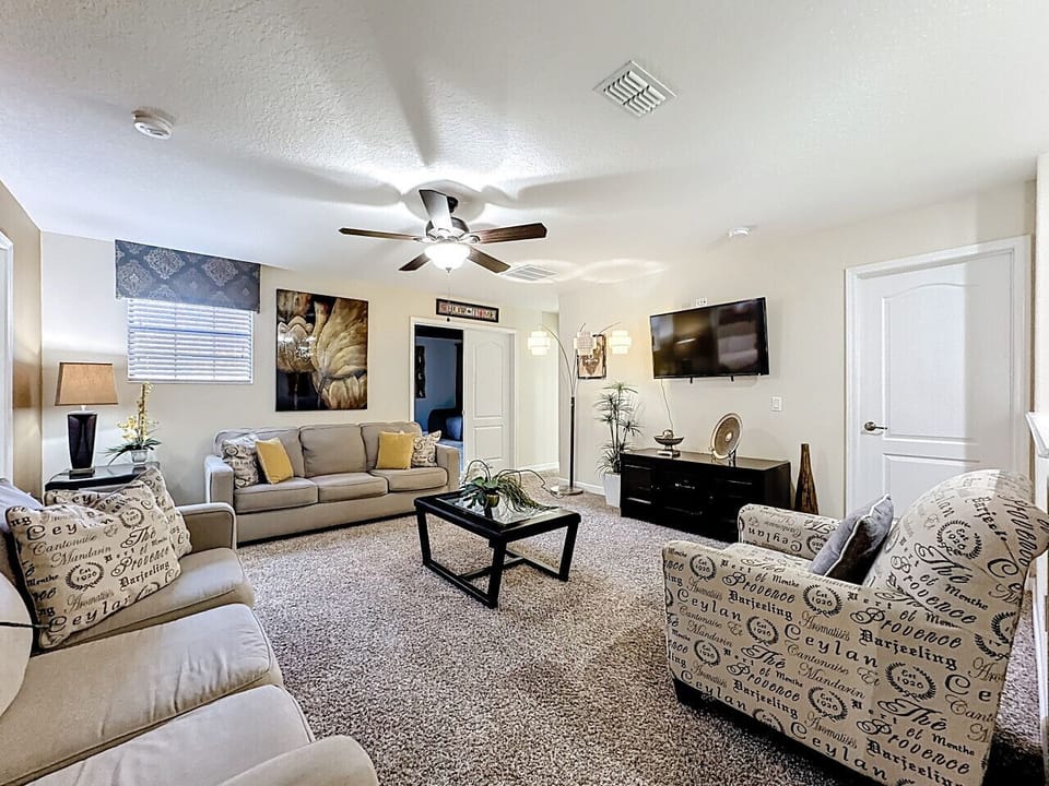 Upstairs seating space featuring comfortable seating and a flat-screen TV.