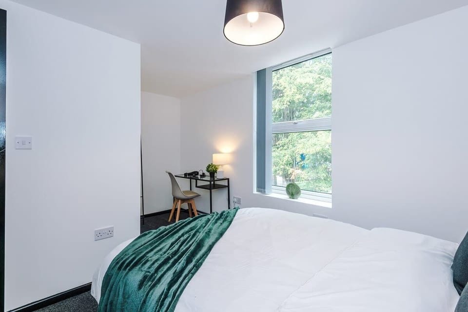 Bedroom: Sunlit retreat with stylish décor, plush bedding, and views of lush greenery outside.