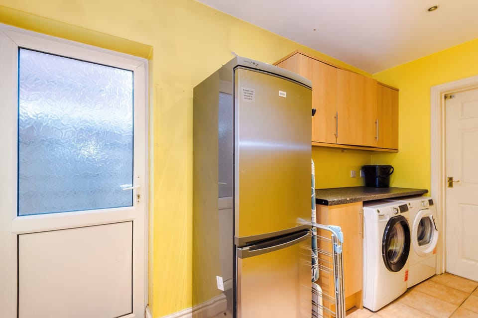 Laundry Room: Bright and functional space with modern appliances and cheerful yellow walls!