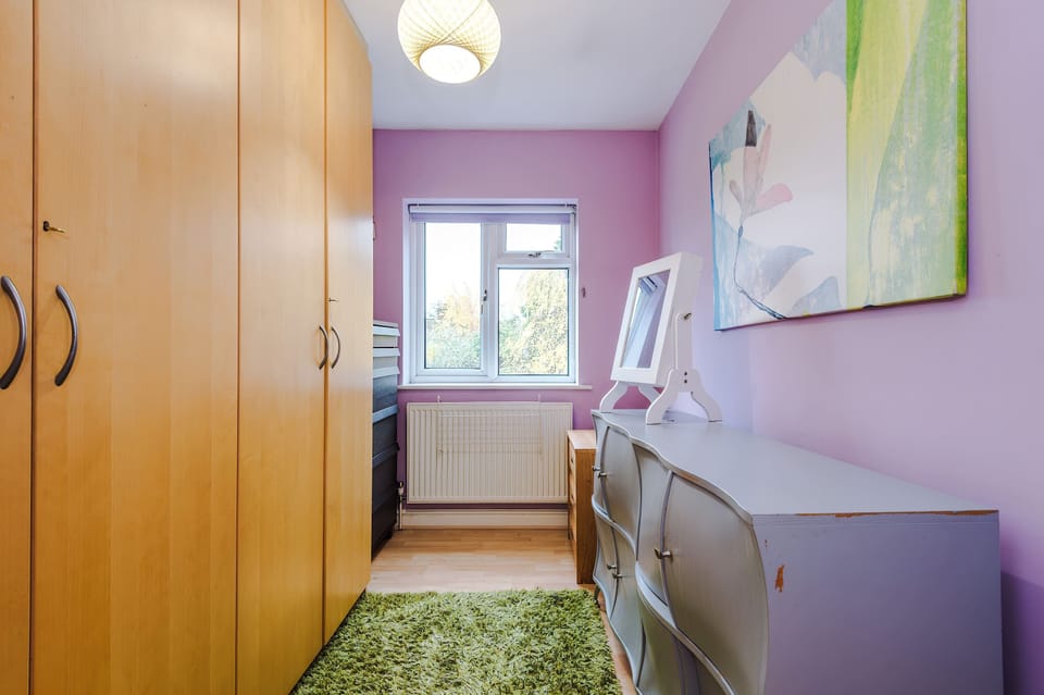 Charming Bedroom: Vibrant purple walls, stylish decor, and bright sunlight await your stay!