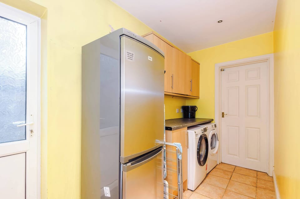 Laundry Room: Bright and functional space with modern appliances and cheerful yellow walls!