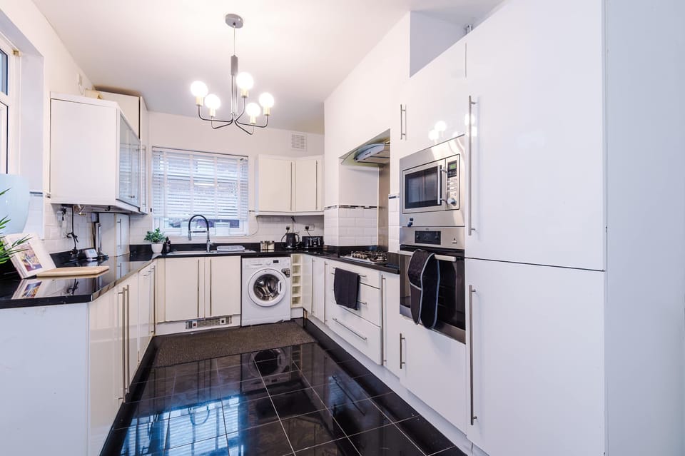 Stylish Kitchen: Sleek black countertops meet modern appliances—ideal for culinary adventures!