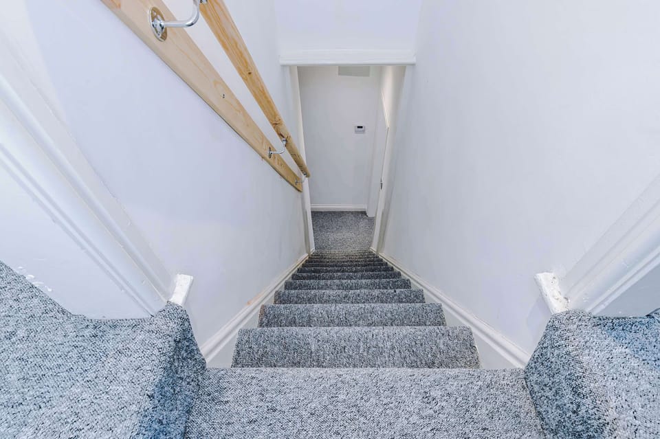 Stairway to Adventure: Elegant, well-lit staircase leading to your relaxing getaway!