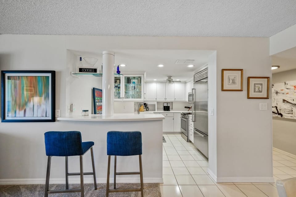 Bright kitchen with sleek white cabinetry and cozy breakfast bar seating