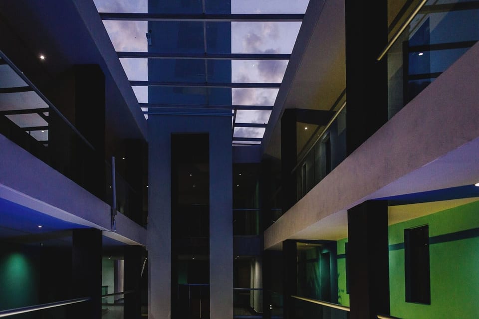 Step into a dramatic atrium glowing with evening ambiance.