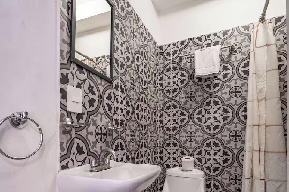 Rinse off comfortably in a clean, patterned-tile bathroom.