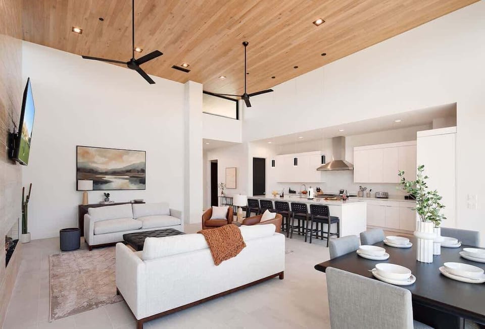 Bright and open living area featuring plush furnishings, a smart TV, and a fireplace.