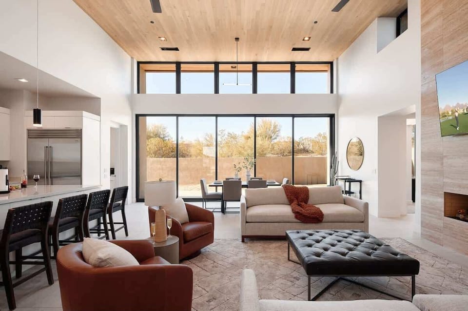 Bright and open living area featuring plush furnishings, a smart TV, and a fireplace.