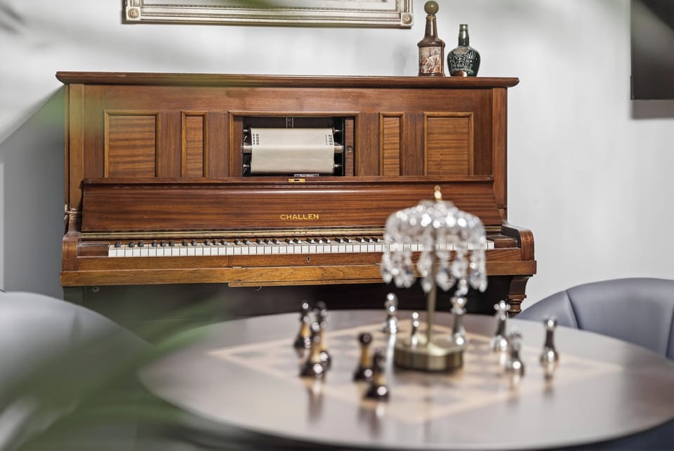 Vintage player piano and game table for relaxed evenings at home.