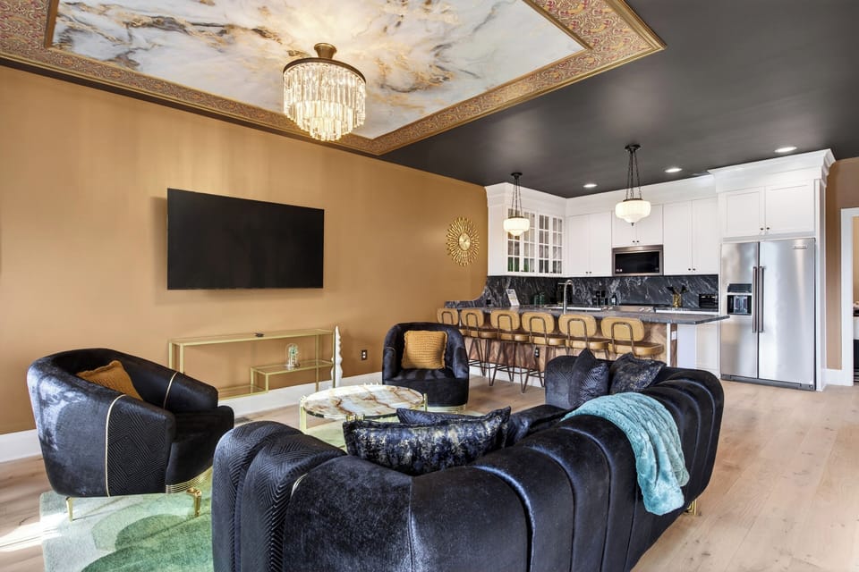Stylish living room with plush seating, statement chandelier, and open-concept layout.