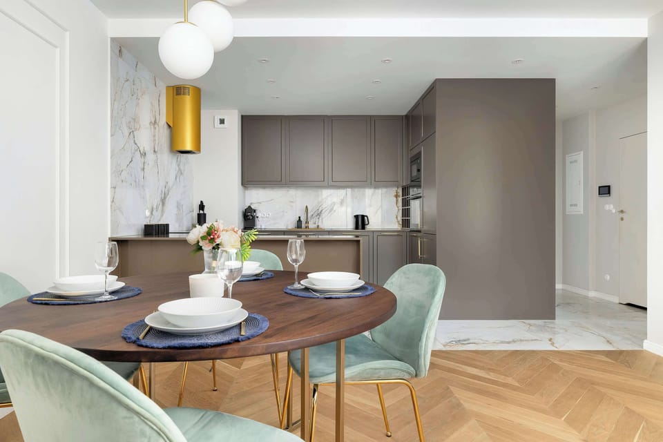 Modern kitchen with elegant cabinetry, marble-style floor, and gold accents.