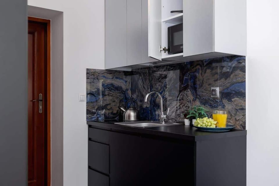 A closer view of the kitchenette, showcasing its sleek design and marble-textured backsplash.
