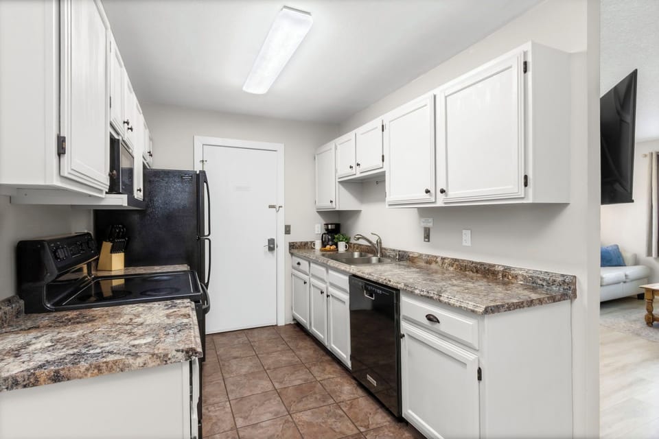 Your bright, fully-equipped kitchen invites you to prepare meals with granite countertops, white cabinets, and modern appliances.