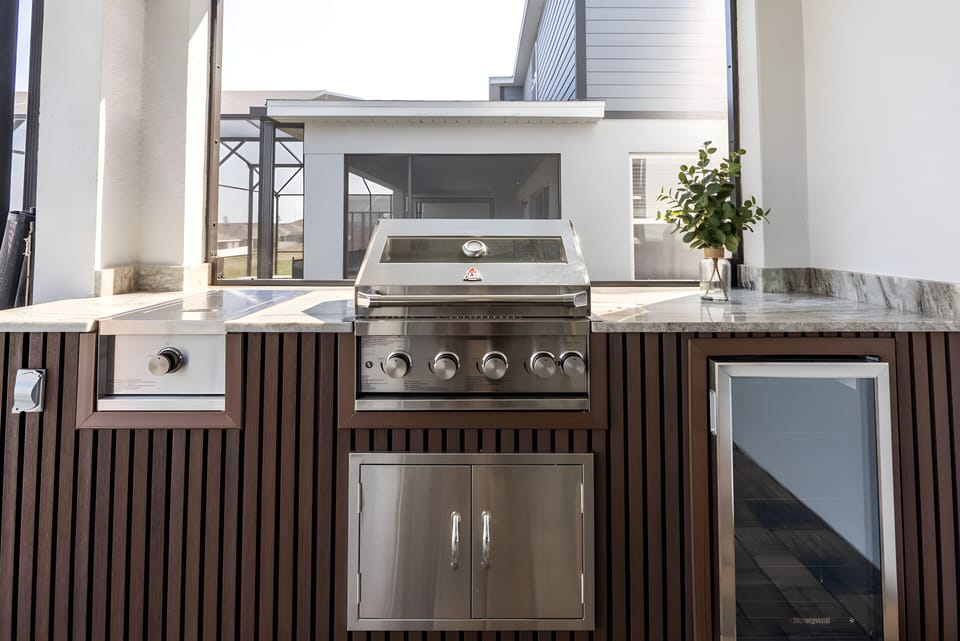Discover the joy of outdoor dining with this sleek grill station featuring stainless steel appliances and natural wood accents. The stylish granite countertop invites you to cook up a feast while enjoying the open-air ambiance.