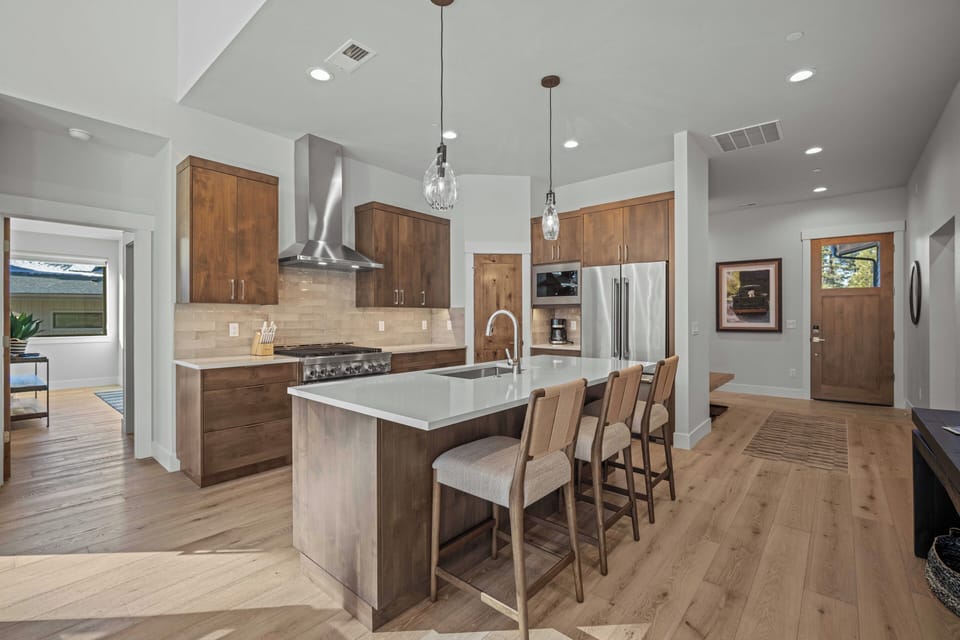 Your spacious chef's kitchen features premium stainless steel appliances, warm wood cabinetry, and a large island perfect for cooking together.