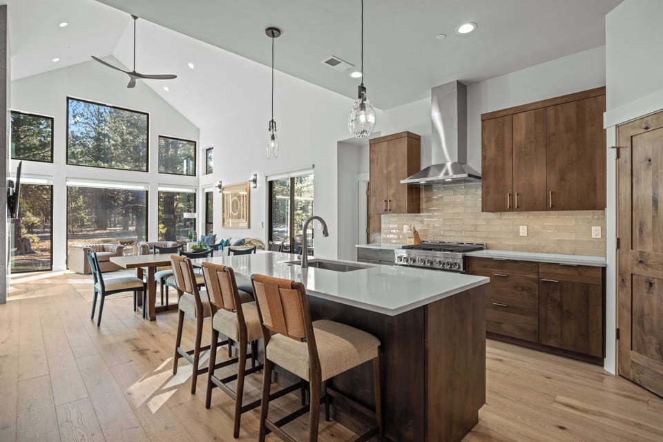 Your gourmet kitchen invites culinary adventures with gleaming counters, professional appliances, and warm wood cabinetry surrounded by natural light.