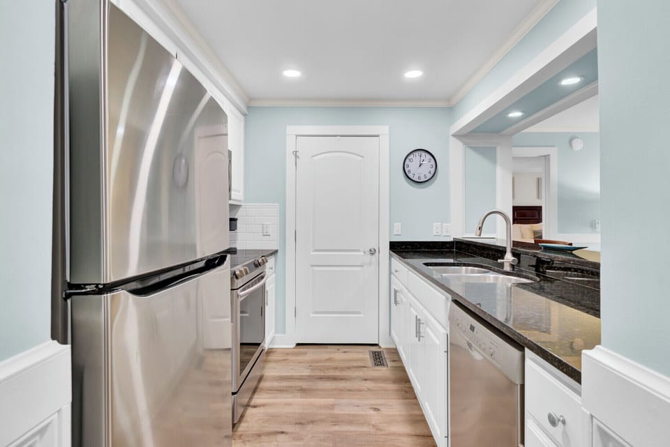 Step into your bright, modern galley kitchen with sleek granite counters and stainless steel appliances ready for your culinary adventures.