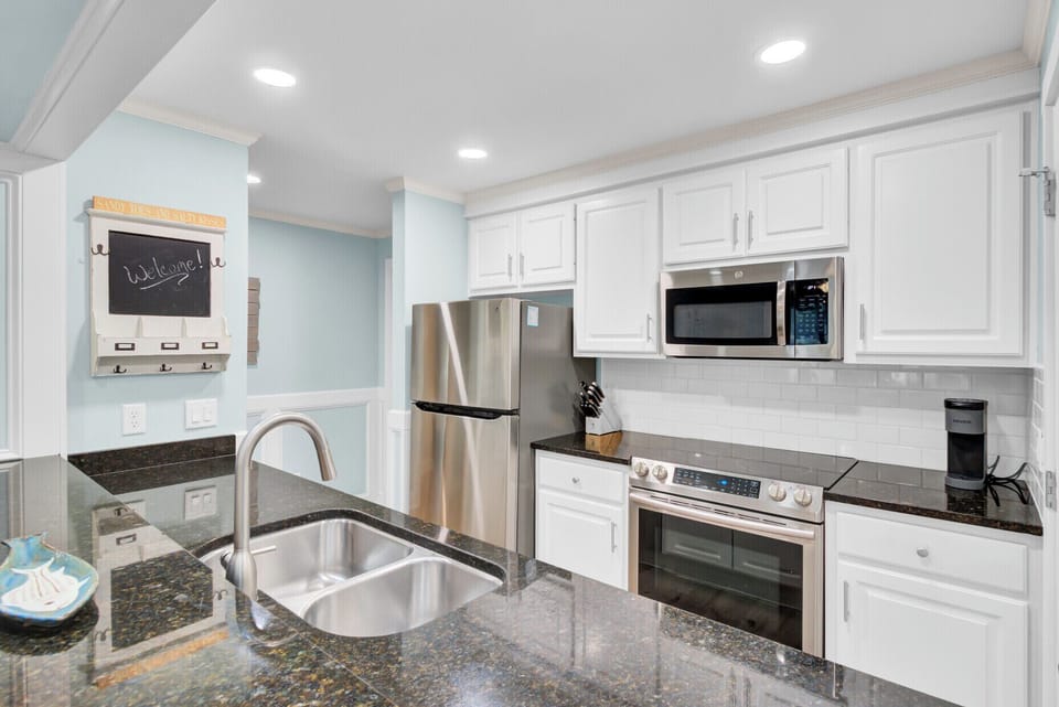 Step into your bright, fully-equipped kitchen with granite counters, stainless appliances, and charming welcome touches that make cooking feel like home.