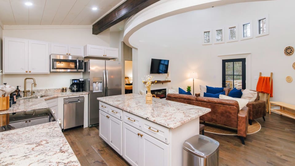 Small footprint, big style. Our open-concept living space features soaring ceilings, two plush leather sofas, and a fully stocked kitchen with quartz countertops and stainless steel appliances.