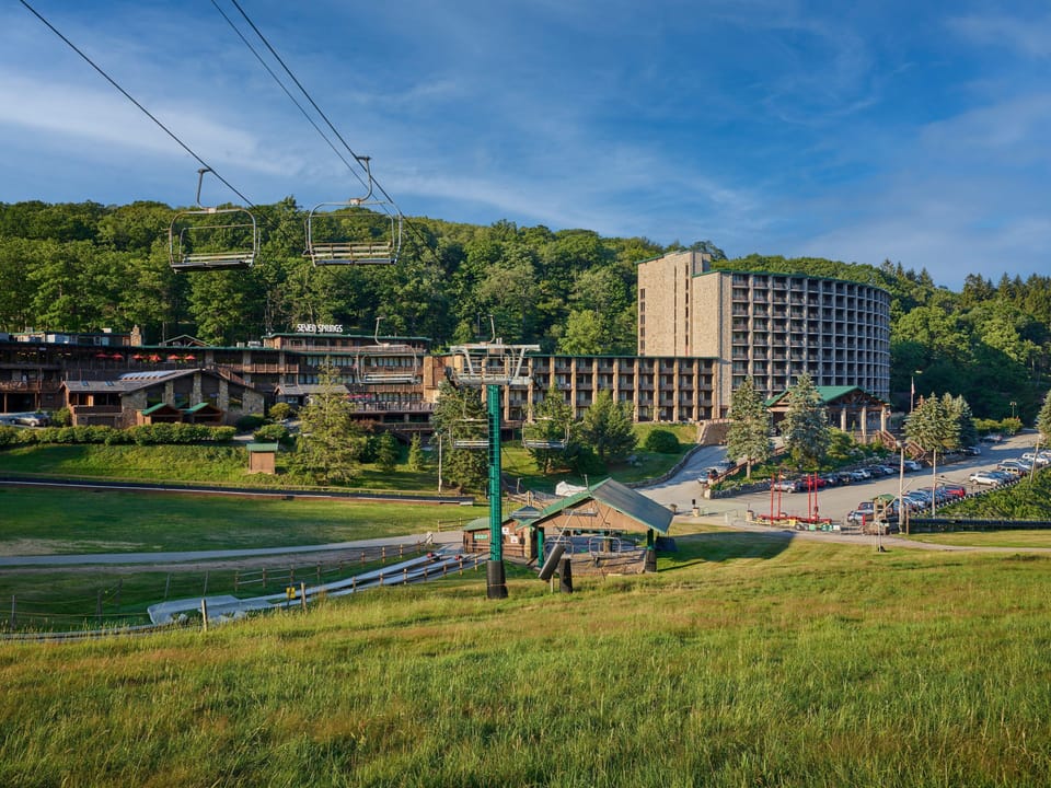 Nestled in lush greenery, the inviting mountain landscape beckons with adventure and tranquility under a bright blue sky.