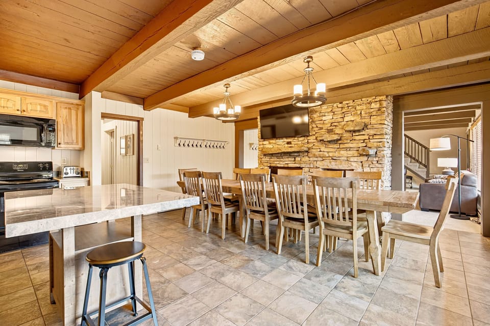 The open kitchen and dining area accommodates up to 18 guests, providing a warm and inviting space for family meals and celebrations.