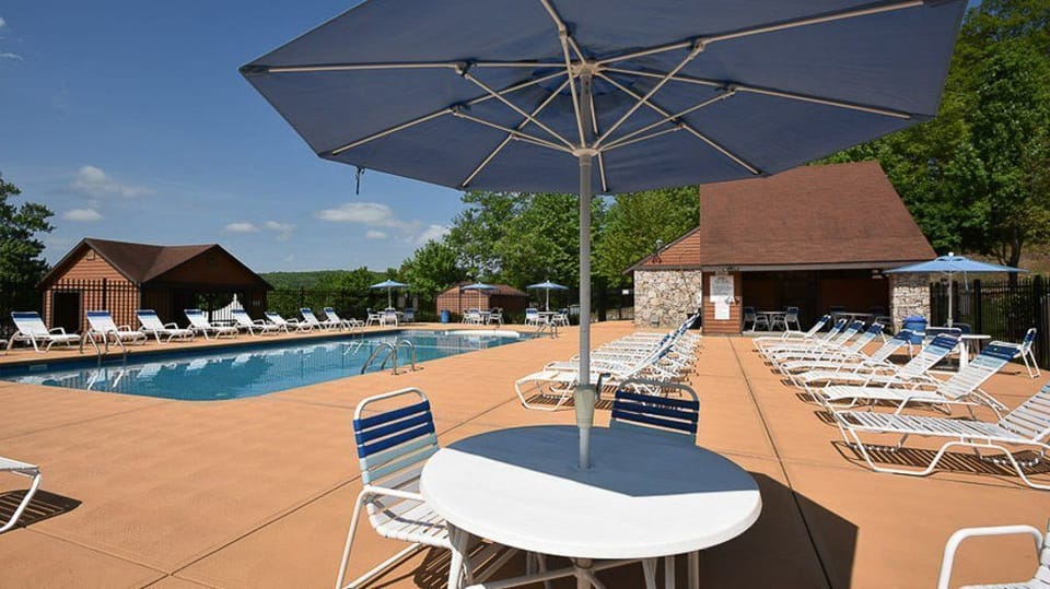 The tranquil pool area, framed by inviting lounge chairs and shaded by umbrellas, offers a serene escape amidst the breathtaking natural beauty of the resort.