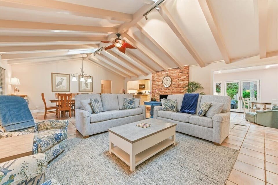 Sun-drenched living room with vaulted ceilings, skylights, and coastal Lowcountry charm.