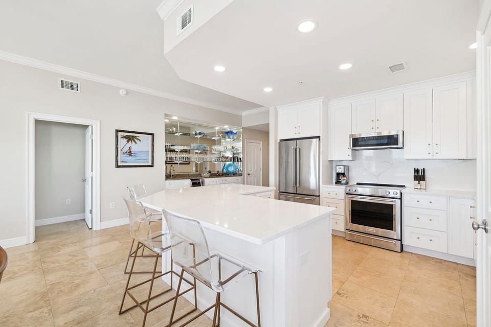 You'll love cooking in this bright, modern kitchen with marble island seating and premium stainless appliances.