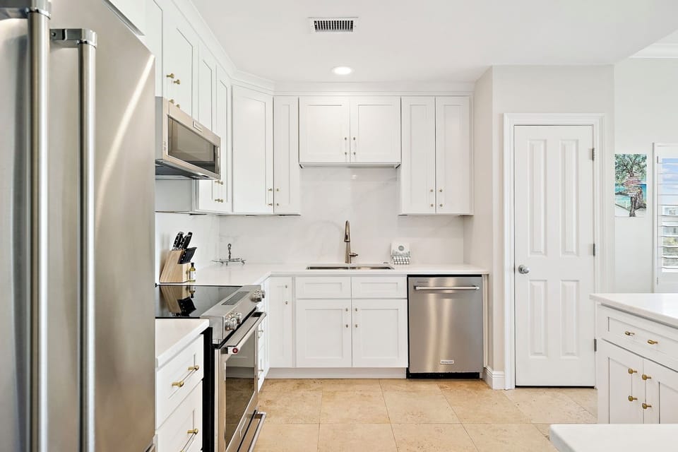Your fully equipped kitchen awaits with modern appliances and elegant white cabinetry for preparing memorable meals during your stay.
