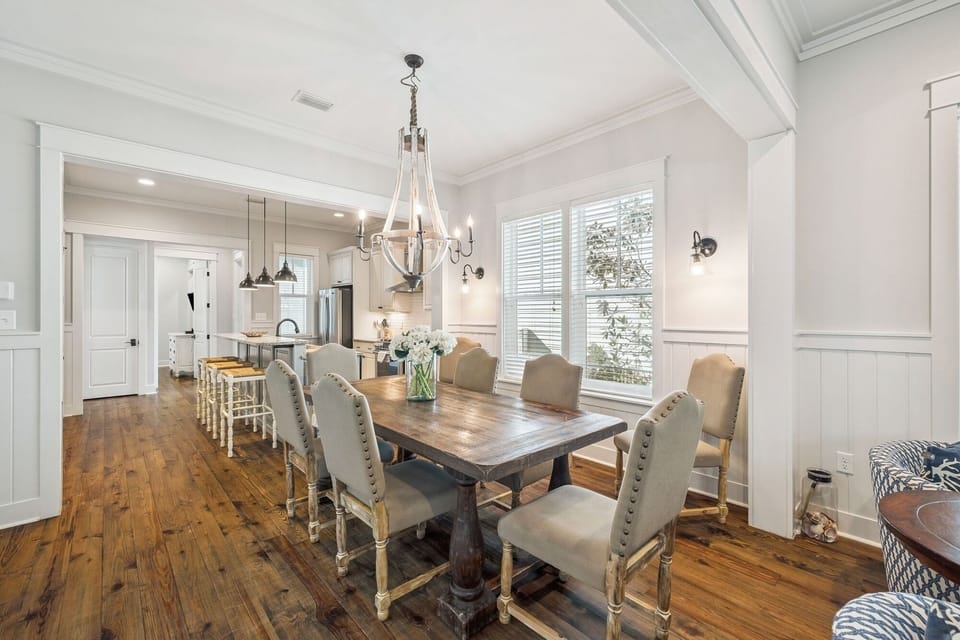 Gather around this elegant dining table for memorable meals with your group, bathed in natural light from large windows.