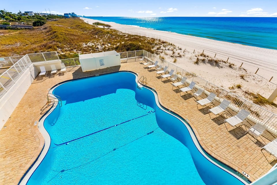 Resort-style oceanfront pool with plenty of loungers for sunny beach days and relaxing afternoons