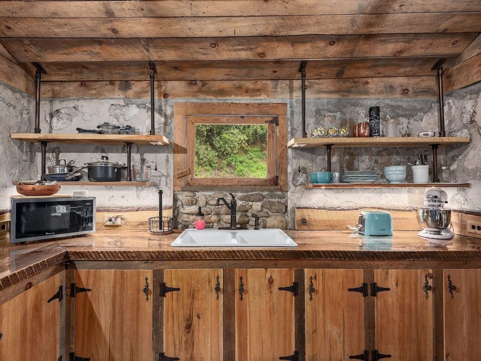 Rustic kitchenette with wood accents, open shelving, and cozy cabin charm throughout the space