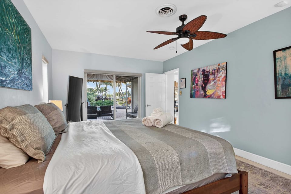 Bedroom 1 with king bed, patio access, and ensuite