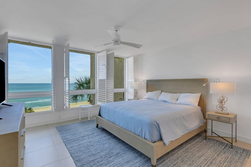 Oceanfront bedroom with panoramic water views and serene decor