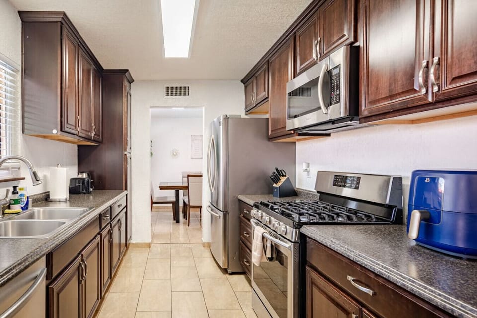 Bright kitchen view with stainless steel appliances and open layout connecting to the dining area.