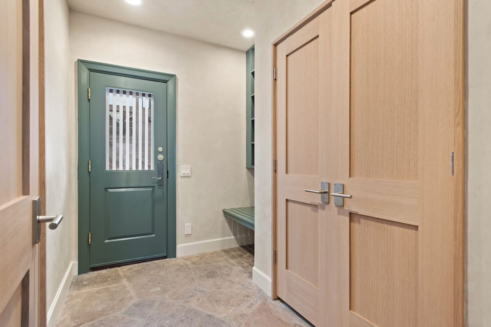 Entry-level floor (back door) with staircase to the top level and lower level. This floor has the primary ensuite bedroom and access to the garage.