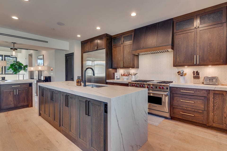 Elegant kitchen with stainless steel appliances, large island, and panoramic views