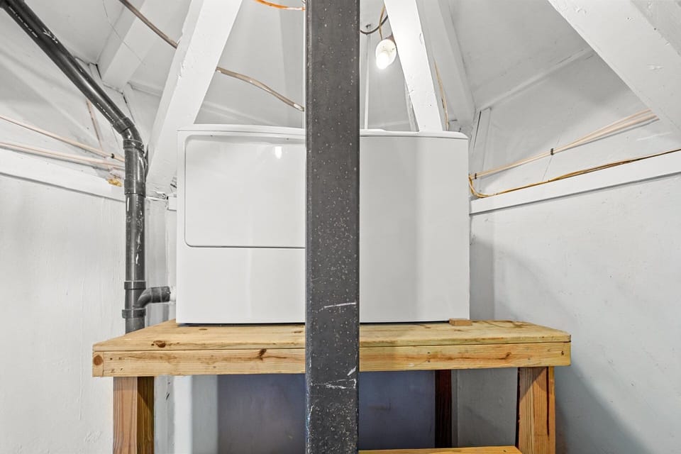 The lower-level storage and laundry area provides space to keep beach gear organized and clean clothes ready, keeping the main living area clutter-free.