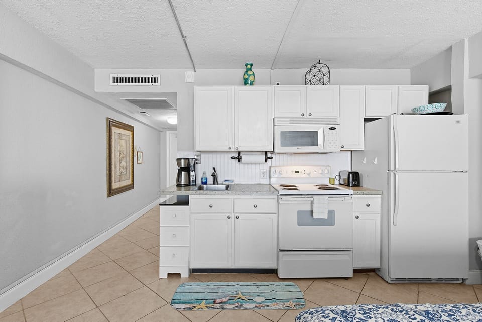 This well-equipped beach stay features a full kitchen with modern appliances, perfect for preparing meals after a day by the ocean. Enjoy the comfort and convenience of a cozy vacation rental just steps from the beach.