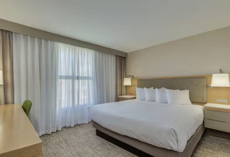 Wake up refreshed beside floor-to-ceiling curtains and comfort.