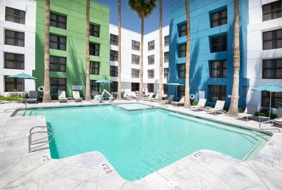 Dive into a vibrant courtyard pool framed by palms.