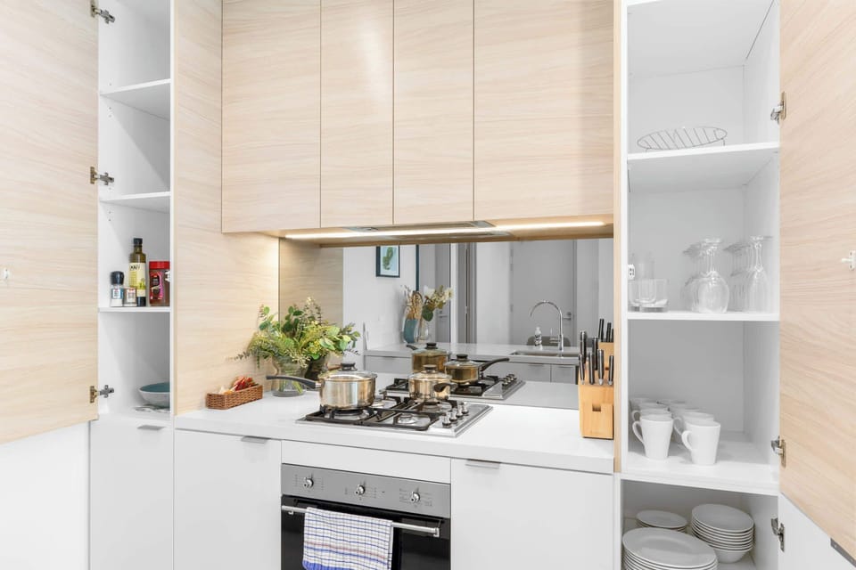Well-appointed kitchen stocked with cookware, crockery, glassware, and essential cooking items.