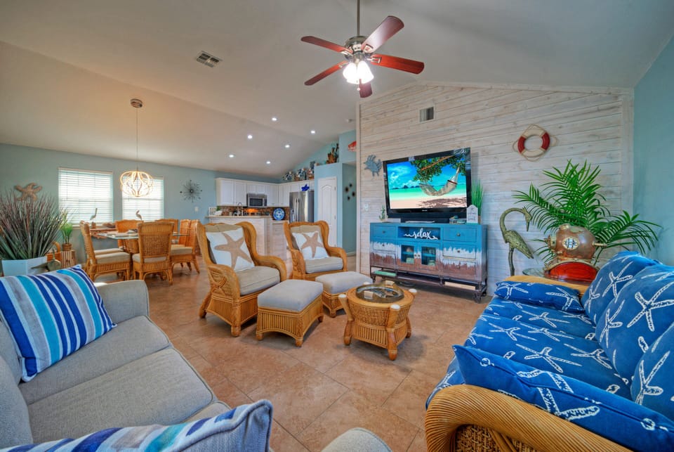 Main living area featuring nautical decor, wicker furniture, and a wall-mounted TV.