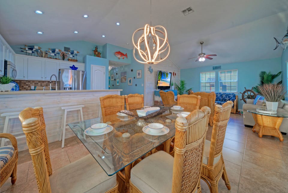 Kitchen and dining area view featuring modern lighting and coastal accents.