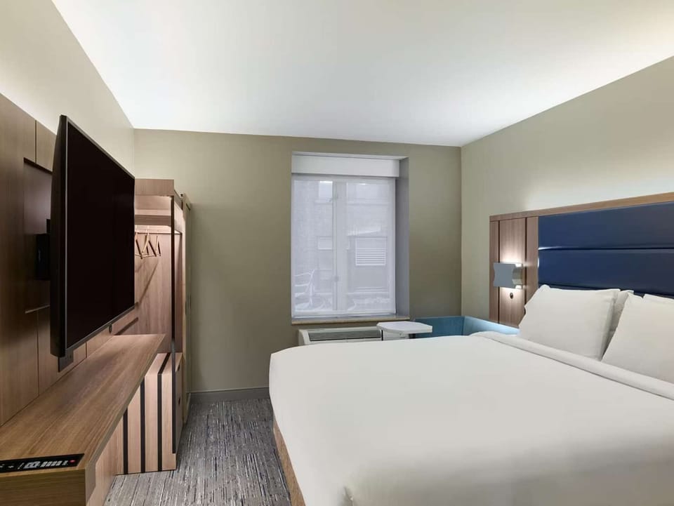 Bright room with king bed, TV, and window light