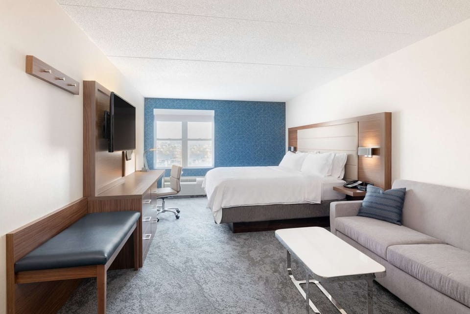 Spacious room with king bed, sofa, desk, and TV